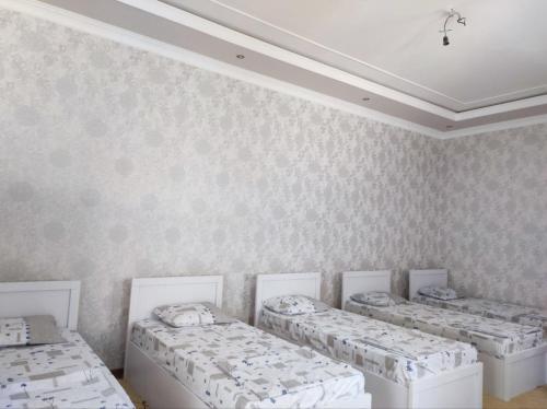 a room with four beds and a ceiling at Saidjanov Hostel in Bukhara