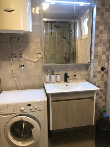 Un baño con lavadora y lavabo. en BonMare.apt4, en Dobra Voda