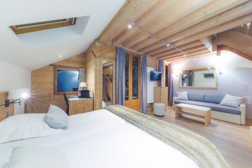 a bedroom with a large bed and a couch at Fleur De Neige Châtel in Châtel