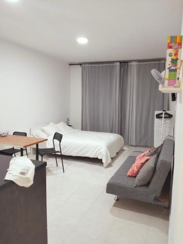 フロンテーラにあるEl Campanario de El Hierroのベッドとソファとテーブルのある寝室