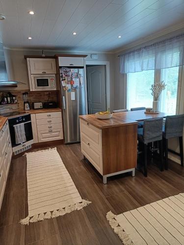 a kitchen with a refrigerator and a table with chairs at Resort Kurjenoja Homestay in Rovaniemi