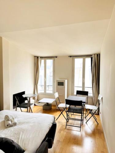 une chambre avec un lit, une table et des chaises dans l'établissement Coeur de Paris - Paris 1er, à Paris