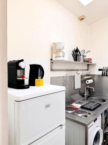 - une cuisine blanche avec cuisinière et lave-linge dans l'établissement Coeur de Paris - Paris 1er, à Paris