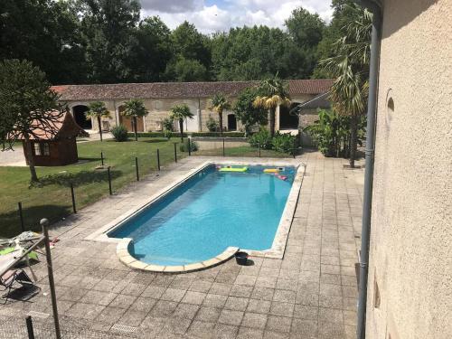 - une vue sur la piscine dans la cour dans l'établissement La maison du parc, à Vervant