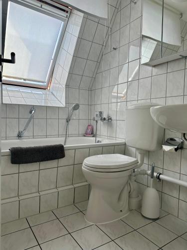 a white bathroom with a toilet and a sink at Birnbom Warnemünde in Warnemünde