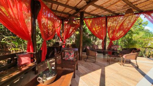 a patio with red curtains and a table and chairs at Mirante de Lençóis in Lençóis