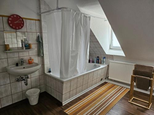 a bathroom with a bath tub and a sink at CityHome am Markt in Saarbrücken