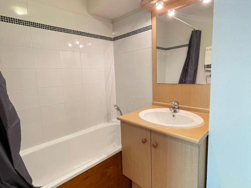 une salle de bain avec un lavabo et une baignoire dans l'établissement Appartement cosy au pied des pistes avec balcon, wifi et parking - FR-1-505-92, à Flumet