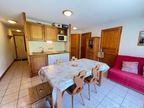 une cuisine avec une table et des chaises dans une pièce dans l'établissement Appartement cosy au pied des pistes avec balcon, wifi et parking - FR-1-505-92, à Flumet