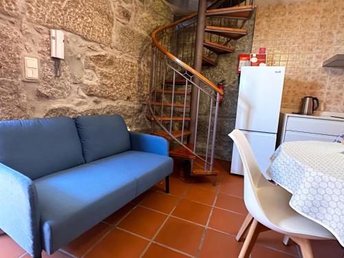 a living room with a blue couch and a table at São Jorge Country House in Penafiel