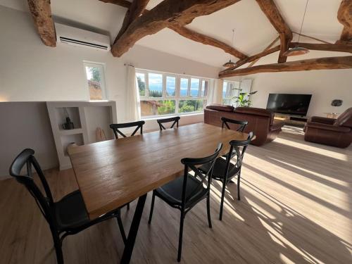 une salle à manger avec une table et des chaises en bois dans l'établissement Maison Atypique vue panoramique, à Moras-en-Valloire