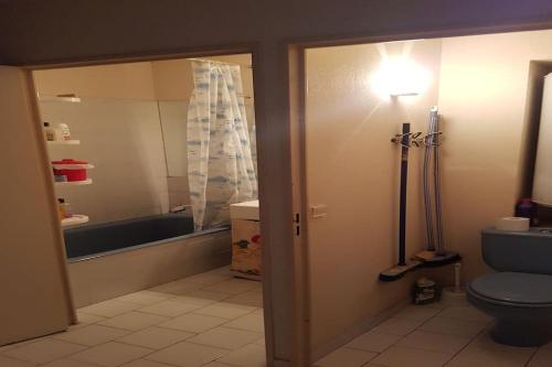 La salle de bains est pourvue de toilettes bleues et d'une baignoire. dans l'établissement Un petit coin de paradis à Sanary sur mer, à Sanary-sur-Mer