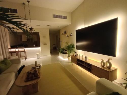 a living room with a large television on the wall at Arabian-Inspired 1BR - Polo Residence Near Burj in Dubai