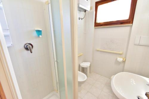 a bathroom with a shower and a toilet and a sink at Eden Park Hotel in Marina di Campo