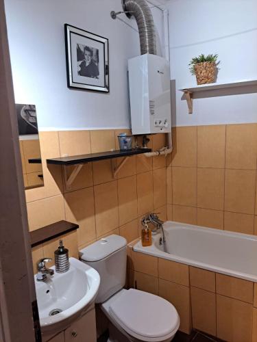 a bathroom with a toilet and a sink and a tub at Comfortable Apartment close to Spodek in Katowice