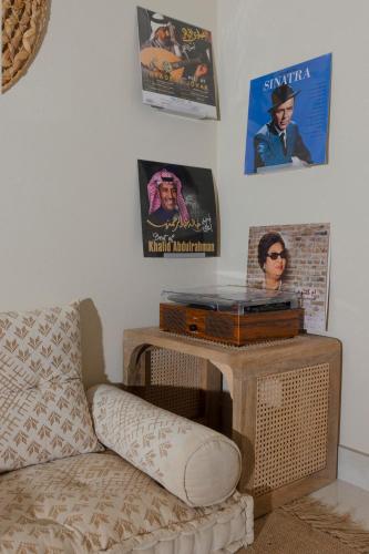 a living room with a couch and posters on the wall at Arabian-Inspired 1BR - Polo Residence Near Burj in Dubai