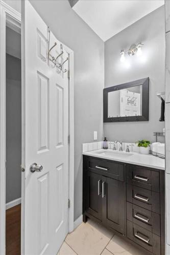 a white bathroom with a sink and a mirror at Sleep 5 - Pet & Baby - Laundry - Closer to Hospitals in Indianapolis