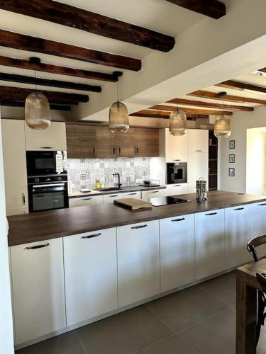 une grande cuisine avec des armoires et des appareils blancs dans l'établissement Charming air-conditioned house with garden & view, à Olmeto