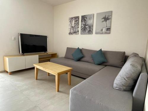 a living room with a couch and a tv at Levitat Hunah in Playa del Carmen