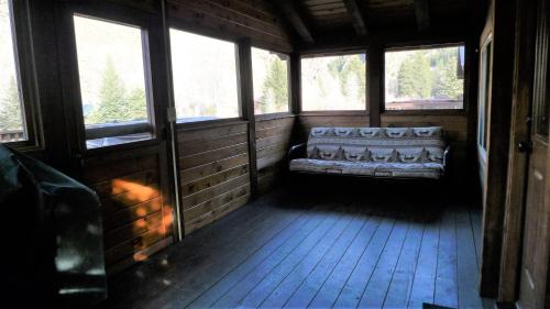 a room with a couch in a room with windows at Cabin 18 in Almont