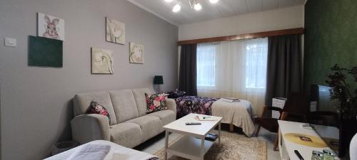 a living room with a couch and a table at Kortteer vihreä huone in Rauma