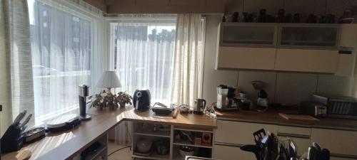 a kitchen with a counter and a large window at Kortteer vihreä huone in Rauma