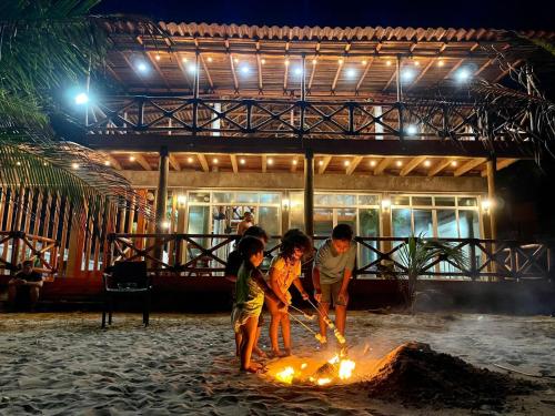 three children are playing around a fire on the beach at Villas Coco Mare Habitacion 5 in Coyuca