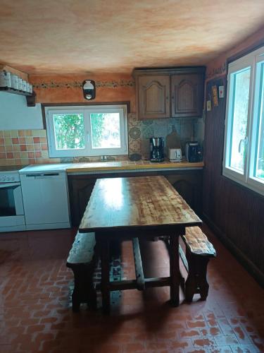 une cuisine avec une table en bois au milieu dans l'établissement Maison dans l'arrière pays niçois entre mer et montagne, à Tourrette-Levens