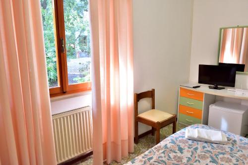 a bedroom with a bed and a desk and a window at Eden Park Hotel in Marina di Campo