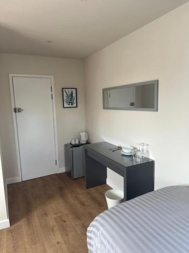 a bedroom with a desk and a bed and a mirror at Cedarwood B&B in Felton