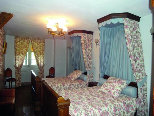 a bedroom with two beds and blue curtains at Château De Saint-Maixant in Saint-Maixant