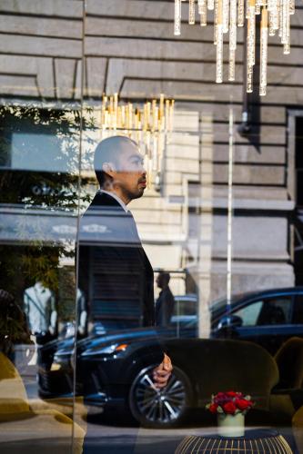 a man reflection in a store window at The Unique Hotel in Milan