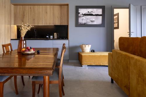 a dining room with a table and a couch at NOI Resort SPA - woda i las in Tęgoborze