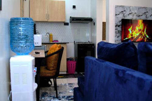 a kitchen with a living room with a fireplace at EDENVILLE HOMES-1 Bedroom Apartment Kiambu Road, Thindigua in Nairobi