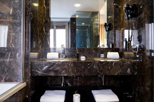 a bathroom with a black marble sink and a mirror at The Unique Hotel in Milan