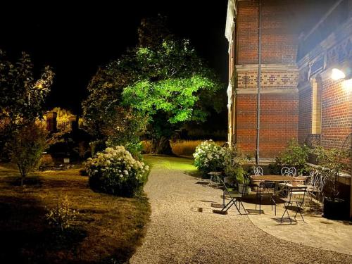 a patio with a table and chairs in front of a building at Le Gîte de Little Castle campagne à 1 h de Paris in Trie-Château