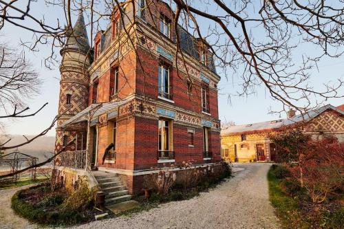 an old brick building with a tower on top at Le Gîte de Little Castle campagne à 1 h de Paris in Trie-Château