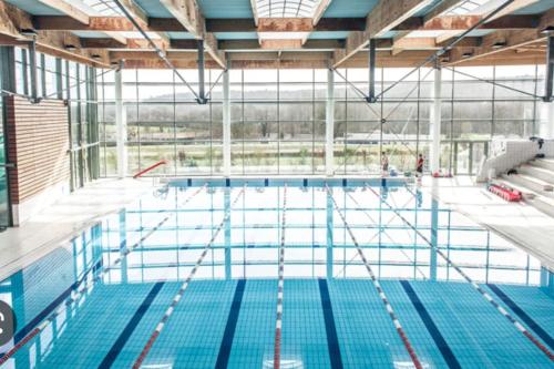 a large swimming pool with a large window at Le Gîte de Little Castle campagne à 1 h de Paris in Trie-Château