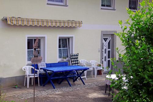 una mesa azul y sillas frente a una casa en Haus Rita en Thurmansbang
