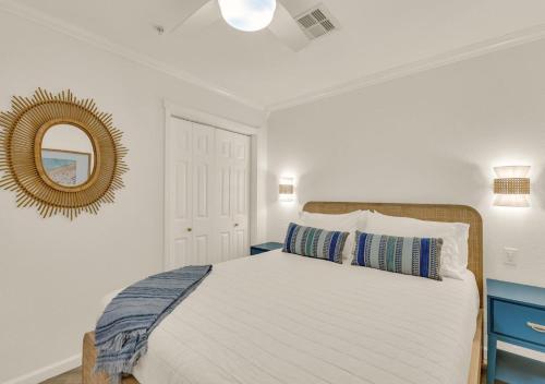 a bedroom with a large white bed with a mirror at Poolside Paradise in Galveston
