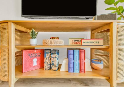 a book shelf with books and a tv on it at Poolside Paradise in Galveston
