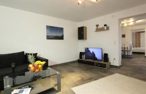 a living room with a couch and a tv at Haus Ingrid in Trauchgau