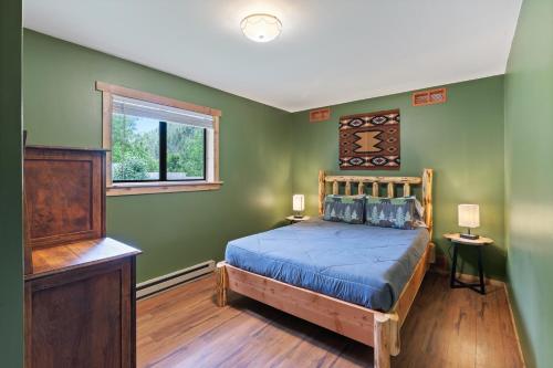 a bedroom with green walls and a bed with a wooden headboard at HTR Durango in Durango