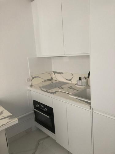 une cuisine blanche avec une cuisinière et un évier dans l'établissement Paris Trocadéro, à Paris