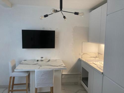 Il comprend une cuisine avec une table et une télévision murale. dans l'établissement Paris Trocadéro, à Paris