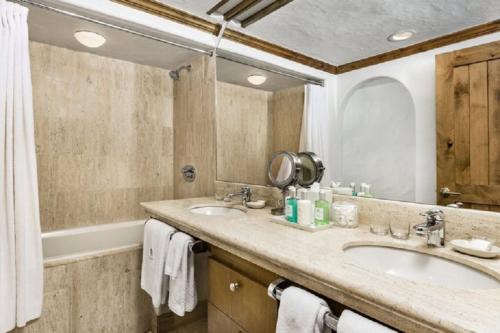 a bathroom with two sinks and a large mirror at Vail Sonnenalp King Hotel Room in Vail
