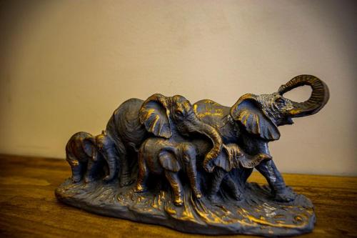 a bronze elephant statue sitting on a table at Black Marble Apartment in Pristina