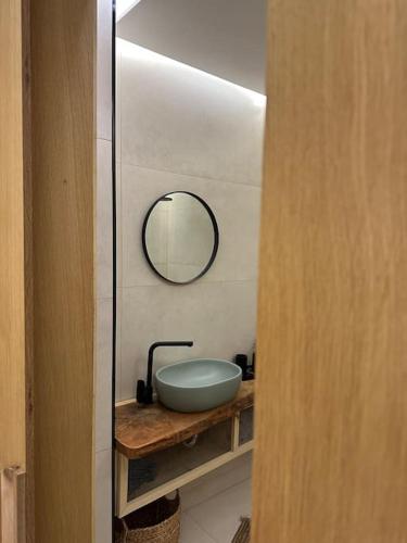 a bathroom with a sink and a mirror on a counter at Black Marble Apartment in Pristina