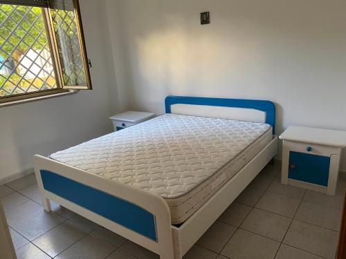 een klein bed in een kamer met een raam bij Casa Marylu con giardino in Marina di Schiavonea