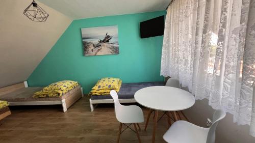 a room with a bed and a table and chairs at Kapitańska Przystań in Chłopy